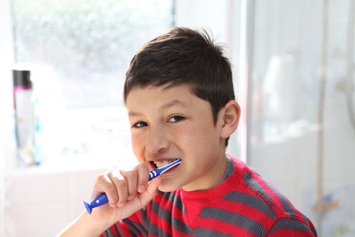 young boy brushing his teeth