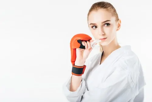 girl boxer holding sports mouthguard