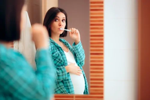 pregnant woman brushes teeth